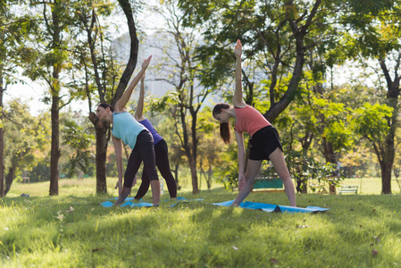 活动在家庭, 母亲和女儿在一个瑜伽垫放松在公园户外, 健康的生活方式和放松的概念