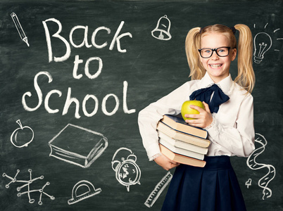 孩子在黑板背景上, 回到学校粉笔画上的黑色黑板上, 快乐的女孩戴着眼镜捧着书和苹果