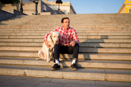 年轻男子和金拉布拉多犬晨行图片