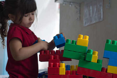 学龄前儿童用塑料块建造塔。幼儿儿童在托儿所