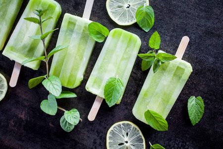 冰淇淋配料黑桌上健康配料的绿色冰棒照片