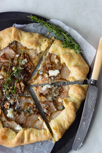 自制的乡村 galette, 有梨, 蓝干酪, 核桃和蜂蜜, 背景清淡。Gallette 有奶油壳和甜水果馅。乡村风格