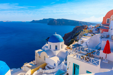 圣托里尼岛, 希腊。伊亚镇传统的白色房子和教堂与蓝色圆顶在口, 爱琴海