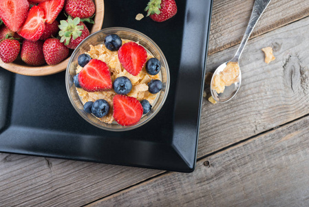 新鲜酸奶与麦片和浆果在木桌, 健康早餐