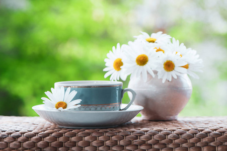 美丽的夏日组成的一杯茶和菊花在自然的绿色背景下, 一个观念好的早晨, 夏日的心情, 幸福