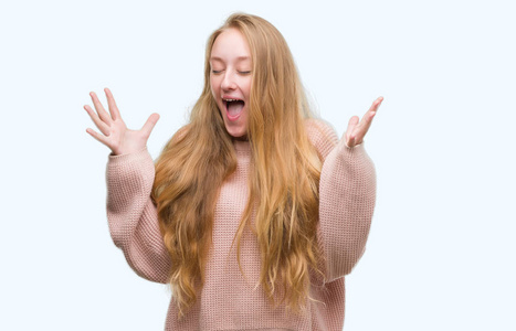 毛衣的金发女郎, 庆祝疯狂和疯狂的成功与手臂举起和闭上眼睛尖叫兴奋