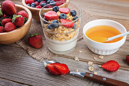 健康早餐, 酸奶与烧瓶, 蜂蜜和浆果在质朴的木桌上