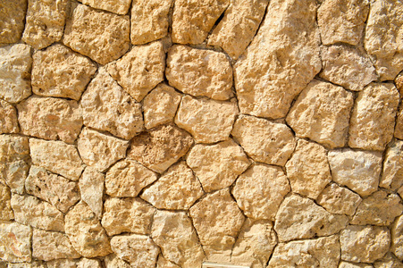 质地的石墙, 道路从石头, 砖块, 鹅卵石, 瓷砖与砂缝的灰色古代自然老黄与尖锐的边缘。的背景