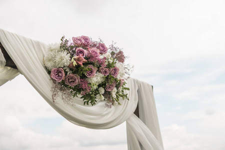 花木拱, 白色的布和新鲜的紫色粉红色的白色花朵与绿叶在一个乡村的婚礼仪式上