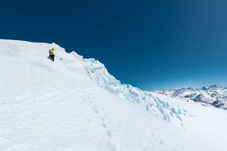 滑雪者在头盔和面具与背包上升的背景下, 雪和冰川。野外随心所欲