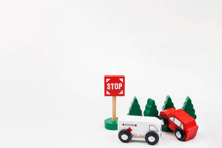 树木繁茂的玩具汽车坠毁。事故道路交通用木制玩具车在镇在白色背景, 安全和交通章程概念, 背景。交通系统概念