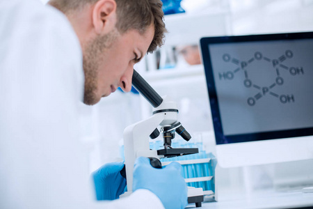 科学家在实验室使用显微镜观察照片
