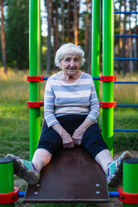 公园运动模拟器上的老年妇女90岁