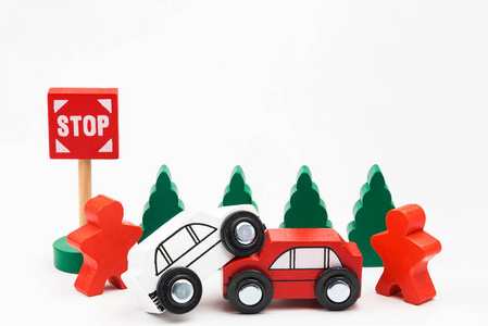 树木繁茂的玩具汽车坠毁。事故道路交通用木制玩具车在镇在白色背景, 安全和交通章程概念, 背景。交通系统概念