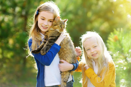 可爱的孩子抱着他们的宠物猫.儿童和动物照片