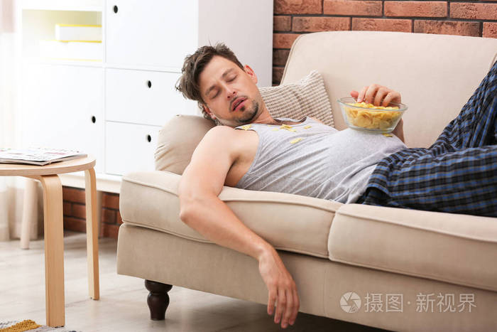 懒人用碗薯条睡在沙发上在家照片-正版商用图片0uruq9-摄图新视界