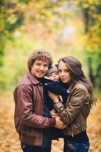 青年家庭拥抱在秋天在公园