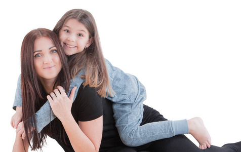 爱的母亲和她的女儿孩子女孩玩和拥抱在白色的背景。快乐的概念。摄影棚拍摄