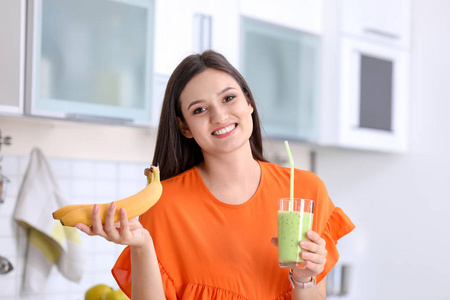 厨房里有一杯可口健康的奶昔的年轻女子