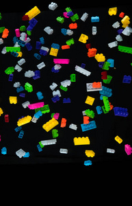 落在黑暗背景上的彩色玩具砖堆