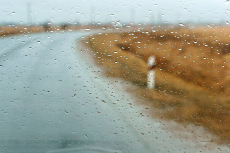 雨在玻璃, 在高速公路上驾驶在大雨, 雨点在汽车玻璃, 湿沥青