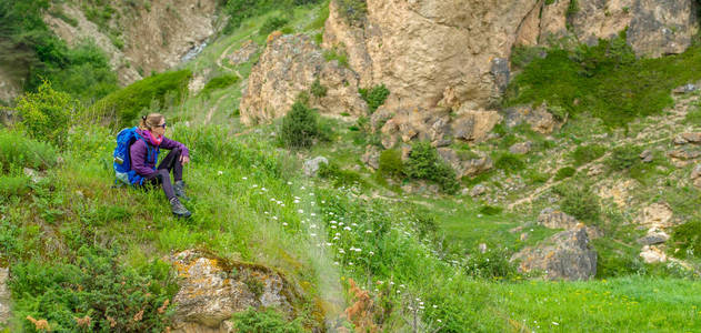 山上有背包的女孩。沿着山路徒步旅行