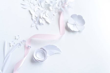 白色背景的白色纸花和粉红色丝带框架。从纸上剪下来。将文本放置