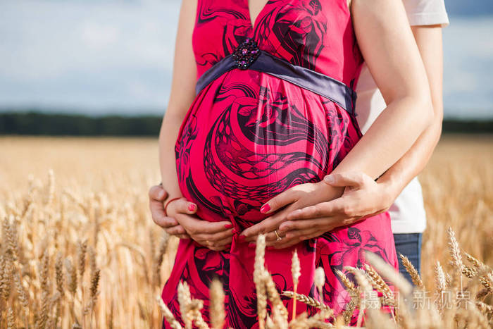 怀孕的女人拥抱她的肚子里