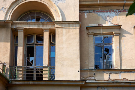 一座旧的废弃建筑, 窗户上有褪色的门面和碎玻璃