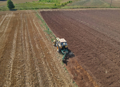 旧拖拉机在耕作土壤后的鸟瞰图