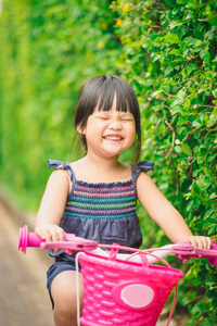 快乐的小女孩骑自行车在公园里