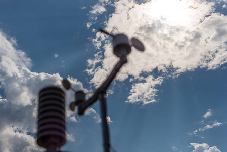 家乡的气象站在蓝天的背景下与太阳在云层后面。温度湿度和风向的测量