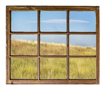 与在科罗拉多山麓通过复古 摇滚 推拉窗与脏的玻璃看到的乾草草原