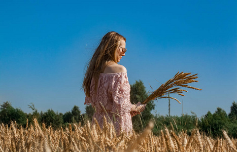 女孩走在田里与麦子
