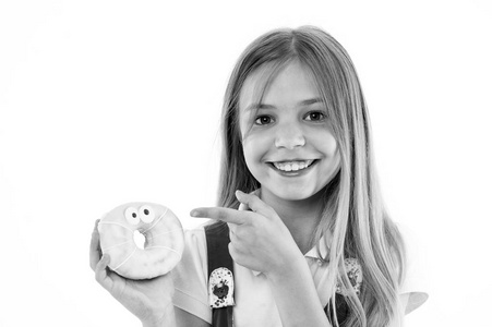 女孩在微笑的面孔拿着甜甜的甜甜圈在手, 隔绝在白色背景。长头发的小孩喜欢甜食和零食。甜食概念。女孩用双眼睛指着甜甜圈