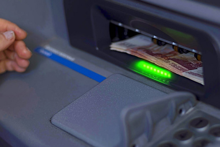一捆纸币插入到开放式 Atm 接收机中。