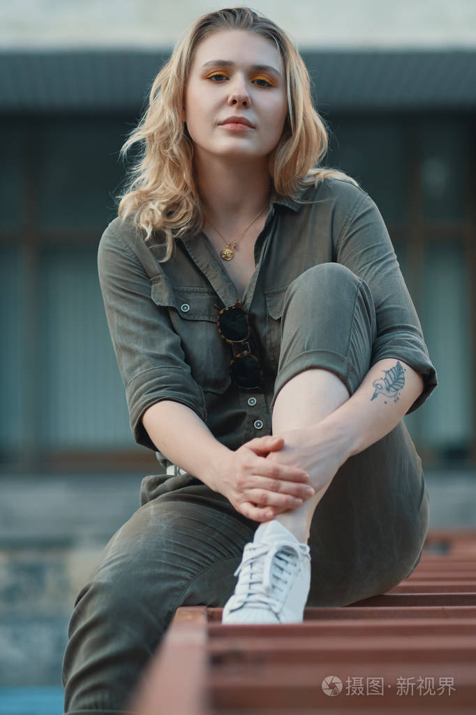 年轻的现代妇女摆在城市户外城市生活