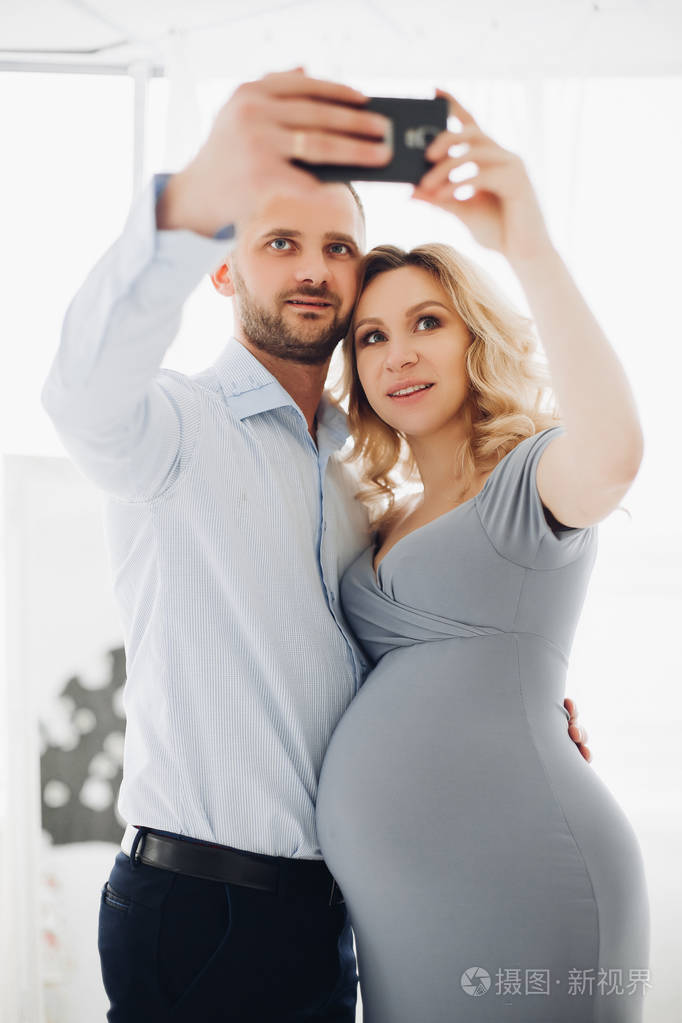 夫妇英俊的男人和怀孕妇女采取自画像