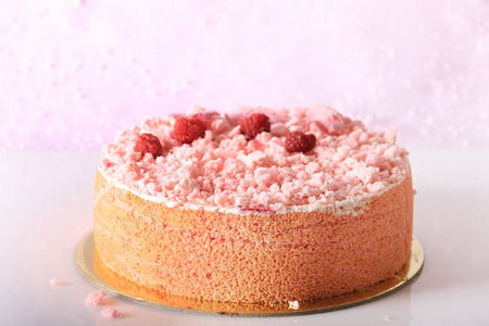 一个粉红色的蛋糕上覆盖着酥皮碎, 覆盆子, 和甜玫瑰花瓣