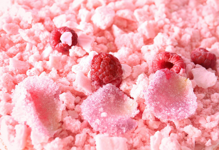一个特写顶部的粉红色蛋糕覆盖的酥皮蛋白碎, 覆盆子和甜玫瑰花瓣