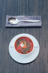 传统的乌克兰俄语罗宋汤在木桌上加奶油。俄罗斯素食红汤白碗