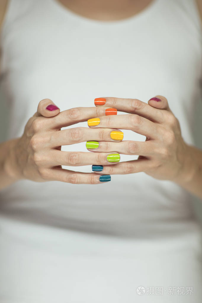 美丽的女人手用五颜六色的彩虹指甲油, 可作为背景使用