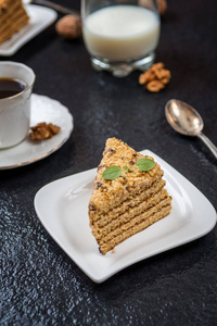 传统甜点蜂蜜蛋糕与核桃和与咖啡在黑暗的石头桌