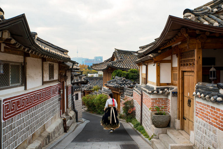 在韩国首尔 Bukchon 韩屋友楼村的首尔传统风格的房子里, 穿着韩的亚洲女人回来了。