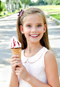 可爱快乐微笑的小女孩孩子吃冰淇淋户外在夏天天