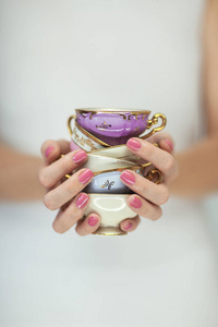 美丽的女人手与完美的粉红色指甲油持有小复古茶杯, 浪漫的破旧别致的心情, 可以作为背景