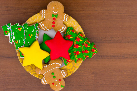 在圣诞树的形状, 姜饼人, 明星和圣诞袜在木桌上的美味节日圣诞饼干板。顶部视图