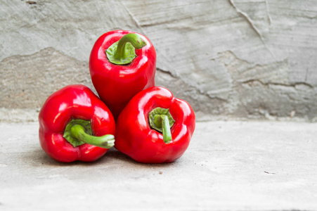 成熟的红辣椒在灰色的具体背景
