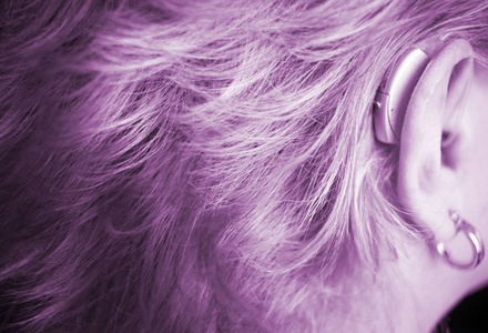 聋女士与现代技术数字助听器在她的耳朵
