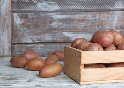 木桌上有新鲜成熟有机土豆的板条箱